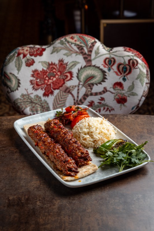 Adana kebab on flatbread with rice