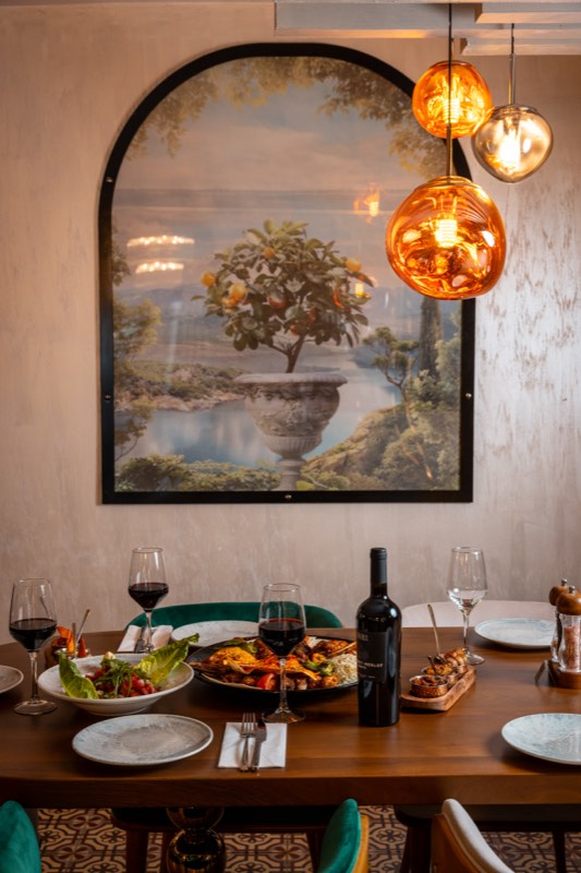 A laid table beneath the arched mural